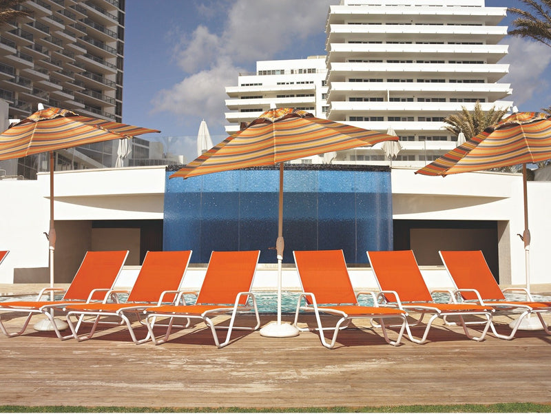 Telescope Casual Gardenella sling chaise lounges lined up at a hotel pool