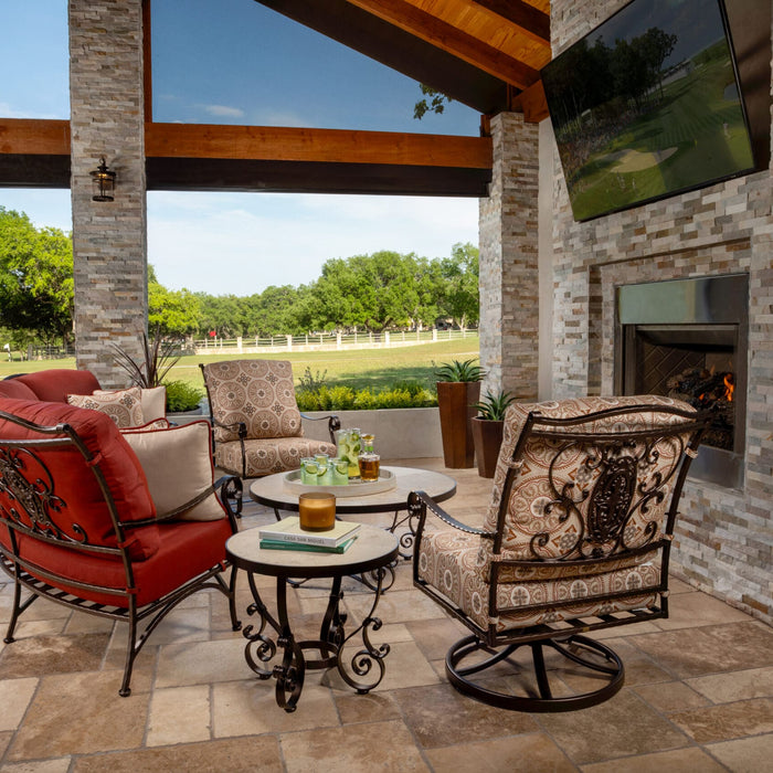 OW Lee San Cristobal curved sectional and swivel rockers in red and patterned cushions on a covered patio with a fireplace