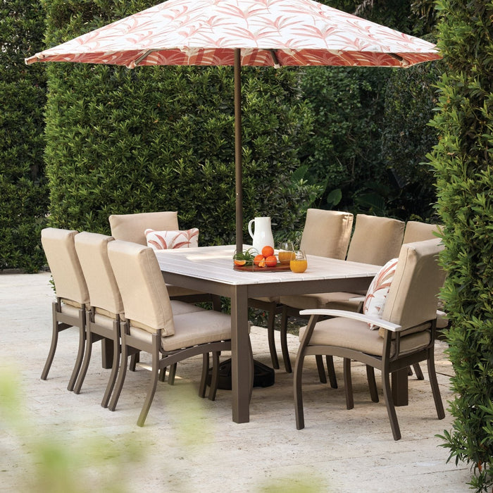 Telescope Casual Belle Isle cushion dining chairs around a Rustic Polymer dining table with an umbrella