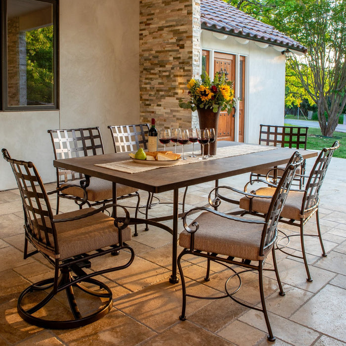 O.W. Lee Classico wrought iron dining table and arm chairs on a stone terrace