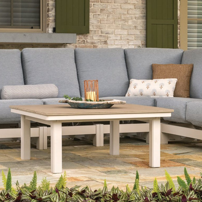 Telescope Casual Leeward sectional with Weathered Wood Rustic Polymer arms on a stone patio