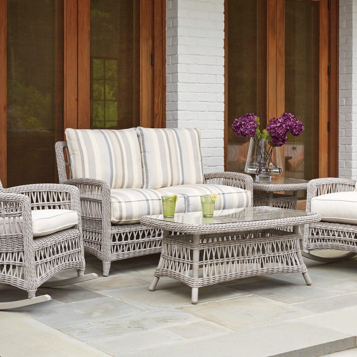 Lloyd Flanders Mackinac loveseat, porch rockers, cocktail table and end table in Putty on a brick porch