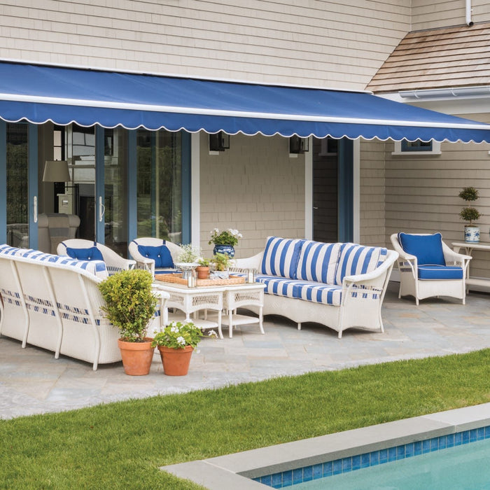 Lloyd Flanders Nantucket wicker sofas and lounge chairs in Ivory with blue striped cushions beside a pool