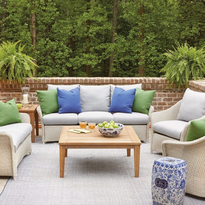 Lloyd Flanders Weekend Retreat sofa, loveseat and lounge chairs in Linen with a teak cocktail table on a brick terrace