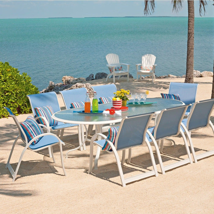 Telescope Casual Aruba II sling dining chairs around a table on a beach