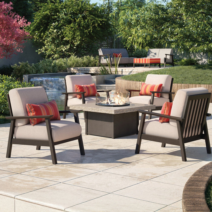 Four Homecrest chat chairs with red striped pillows around a square fire table on a garden patio