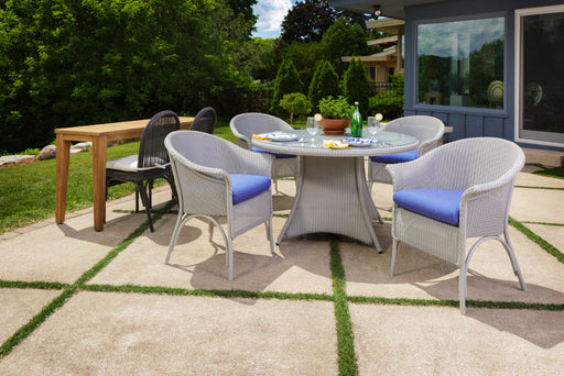 Lloyd Flanders Universal Loom classic dining armchairs around a round pedestal table on a patio