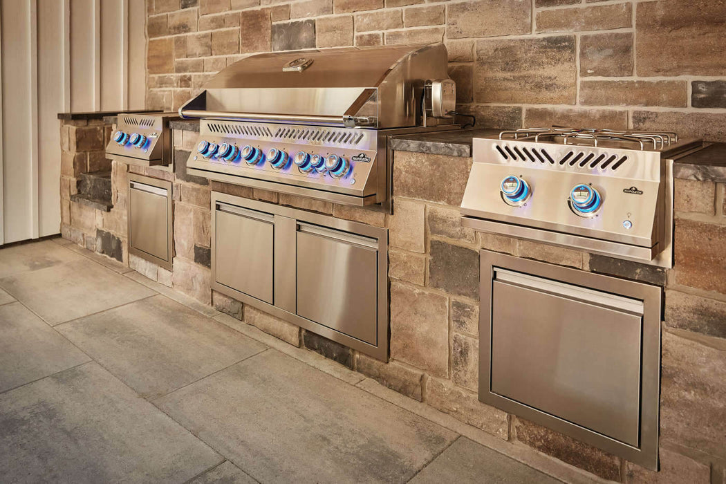 Power burner beside a Built-In 700 Series grill in a stone outdoor kitchen