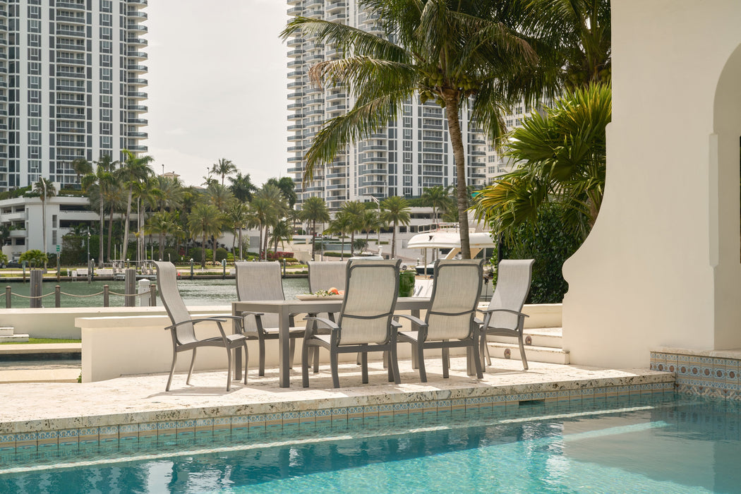 Belle Isle sling dining chairs around an Origins rectangular dining table by the pool