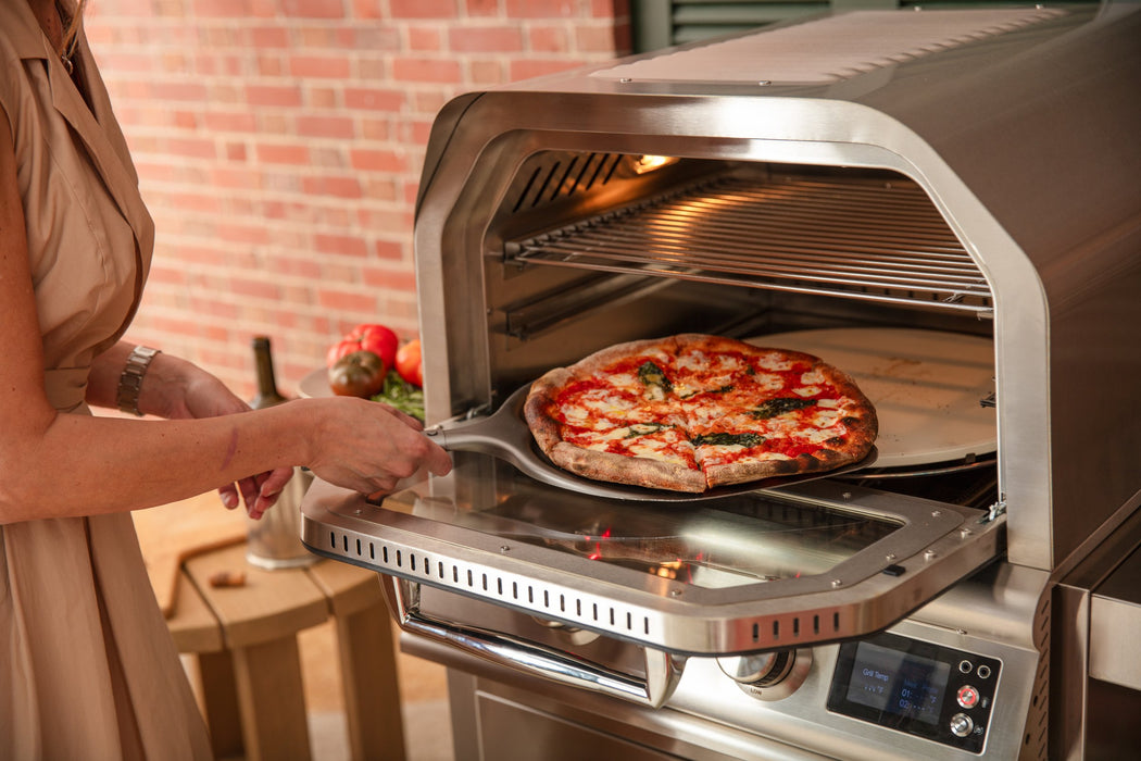 Blaze LTE+ 26" outdoor pizza oven, pizza going into the oven on a peel