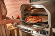 Blaze LTE+ 26" outdoor pizza oven, pizza going into the oven on a peel