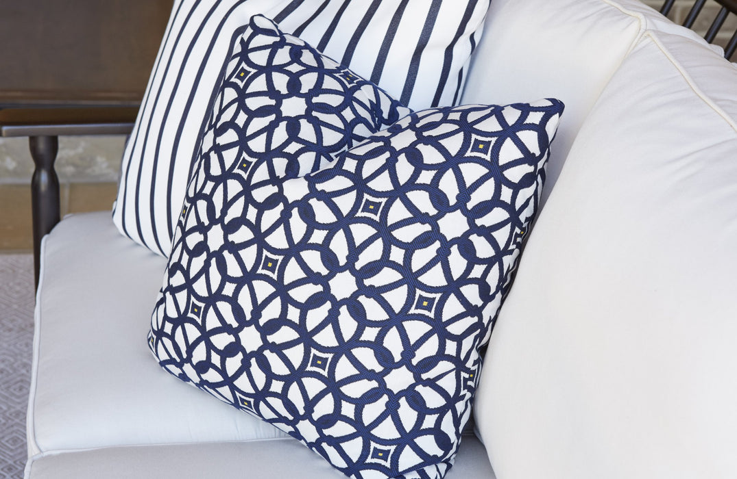 Navy lattice and stripe Lloyd Flanders throw pillows on a white cushioned sofa