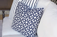 Navy lattice and stripe Lloyd Flanders throw pillows on a white cushioned sofa