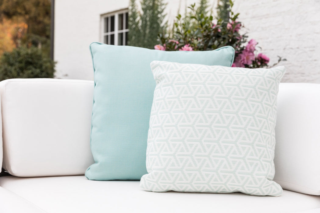 Aqua and white geometric Lloyd Flanders throw pillows on a white sofa