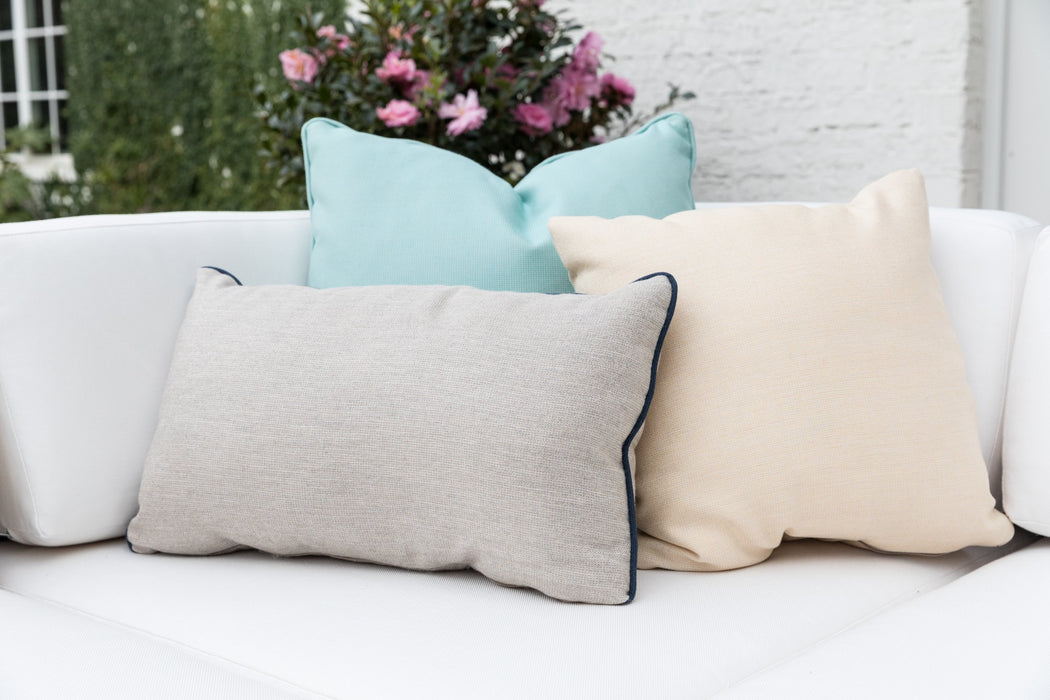Lloyd Flanders lumbar and square throw pillows with navy contrast welt on a white sofa