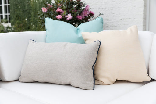 Lloyd Flanders lumbar and square throw pillows with navy contrast welt on a white sofa