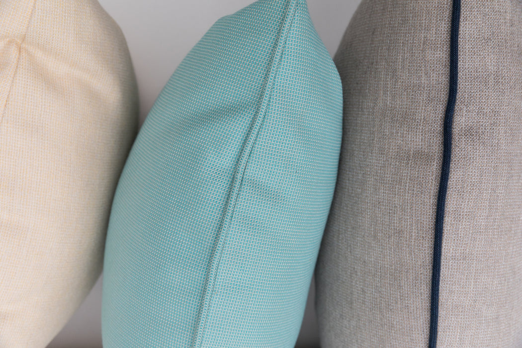 Close-up of Lloyd Flanders throw pillow welt details in cream, aqua and gray