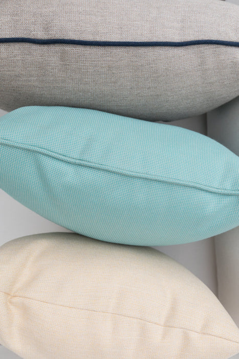 Lloyd Flanders throw pillows stacked, gray with navy welt over aqua and cream
