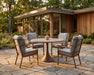 Woodard Brit dining arm chairs around a table (table sold separately; stationary chairs shown)