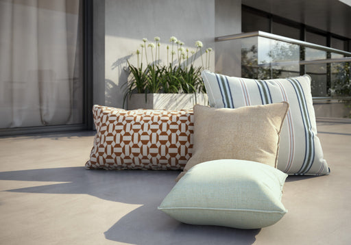Homecrest outdoor throw and kidney pillows on a terrace