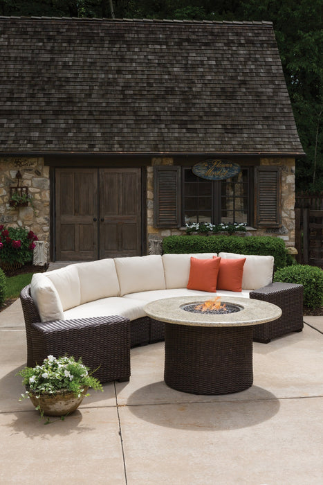 Lloyd Flanders Mesa curved sectional and fire table beside a garden cottage