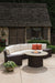 Lloyd Flanders Mesa curved sectional and fire table beside a garden cottage