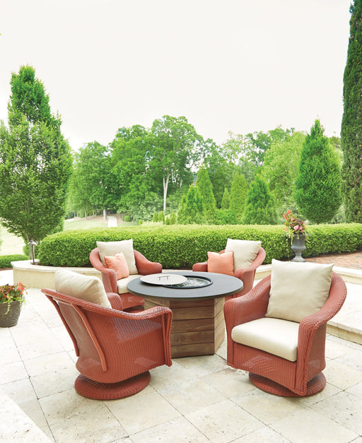Lloyd Flanders Reflections swivel rocker lounge chairs in Terracotta around a fire table