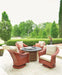 Lloyd Flanders Reflections swivel rocker lounge chairs in Terracotta around a fire table