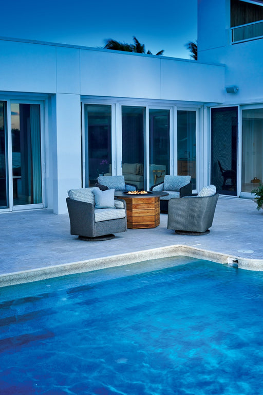 Lloyd Flanders Visions swivel gliders around a teak fire table by a pool