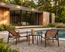 Woodard Louie Sling Chaise Lounge Set of 2, shown in a Woodard outdoor setting (the side table shown is not included)
