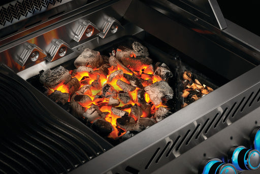 Napoleon cast iron charcoal and smoker tray glowing with charcoal inside a gas grill