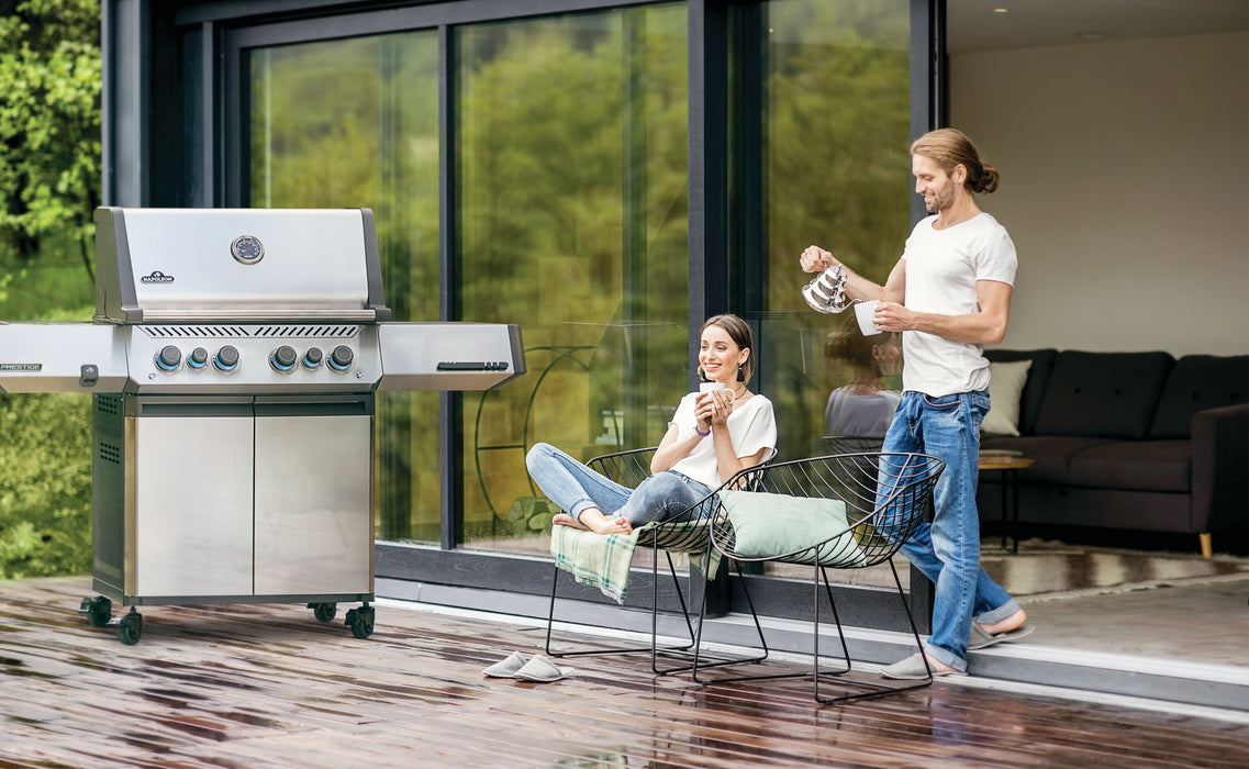 Napoleon Prestige 500 stainless steel gas grill on a modern wood deck patio