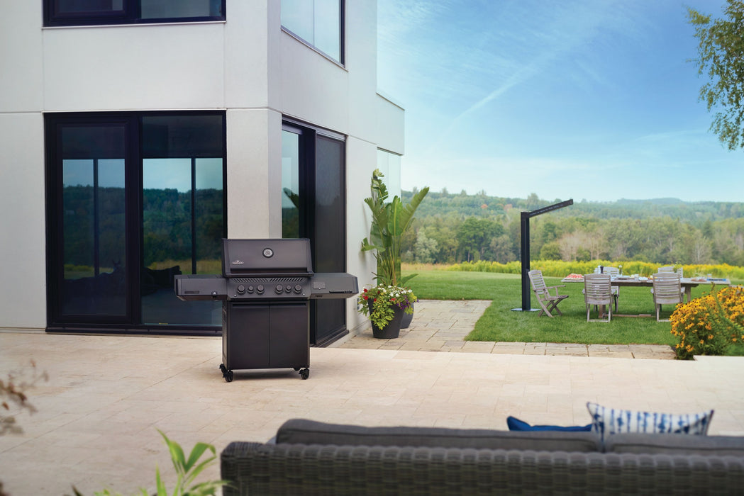 Napoleon Phantom Prestige 500 Connected matte black gas grill on a stone patio