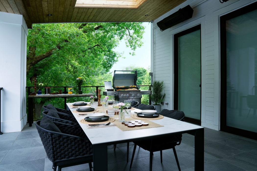 Stainless Rogue PRO 525 on a covered patio beside the dining table