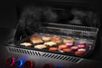 Napoleon stainless steel griddle insert with burgers and onions on a Prestige grill