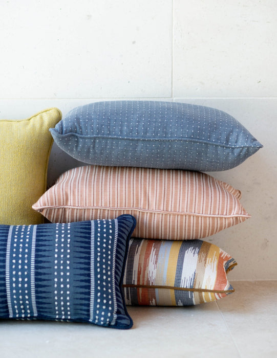 A stack of OW Lee Design Harmony throw pillows with welt edges