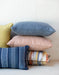 A stack of OW Lee Design Harmony throw pillows with welt edges
