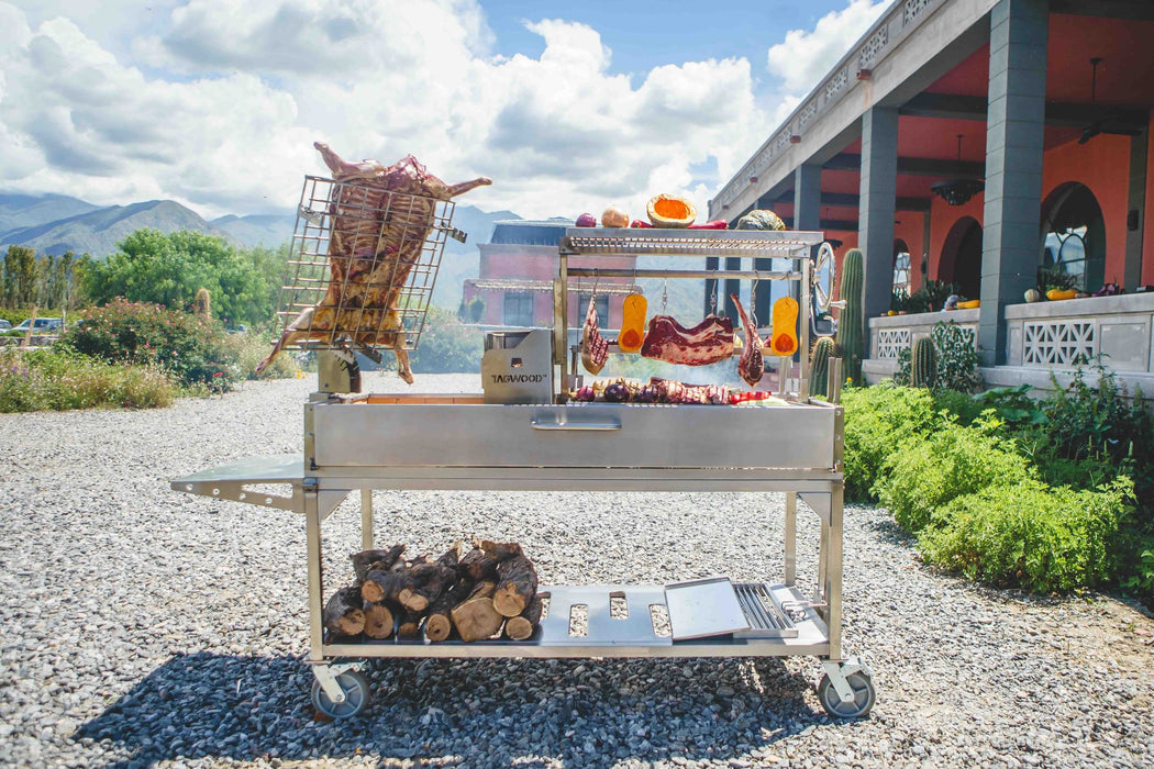 Tagwood BBQ26SS loaded with meat on a gravel patio