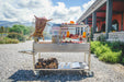 Tagwood BBQ26SS loaded with meat on a gravel patio