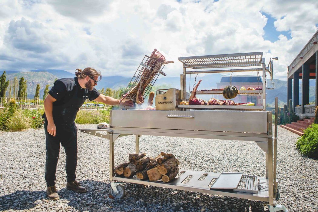 Chef tending the fire on a Tagwood BBQ26SS in the mountains