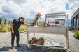 Chef tending the fire on a Tagwood BBQ26SS in the mountains