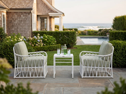 Woodard Cane 3-piece lounge set in White: two lounge chairs and an end table on a seaside patio