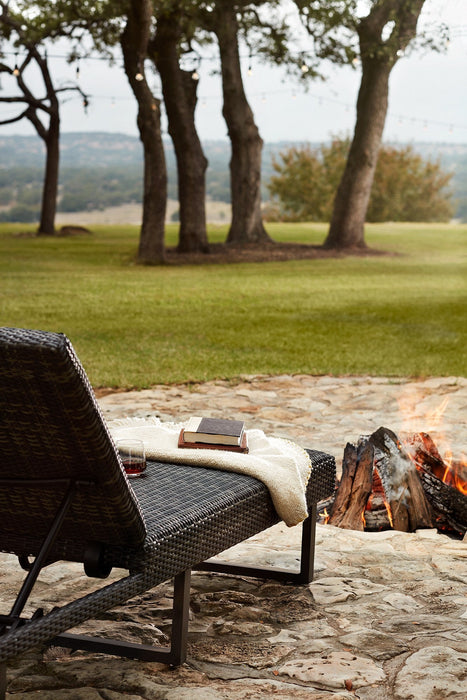 Woodard Harper chaise lounge by an outdoor fire pit