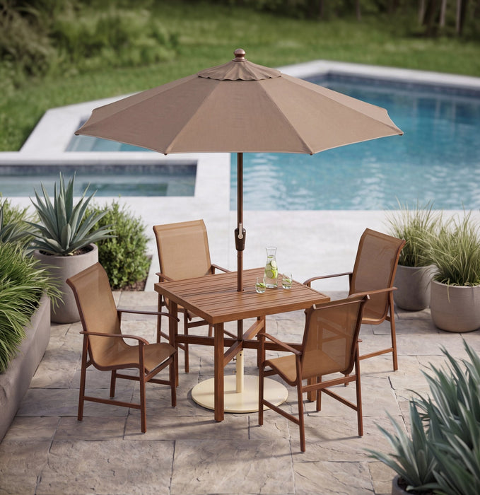 Woodard market umbrella over a dining set
