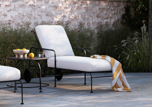 Woodard Reed chaise lounge with white cushions by a pool
