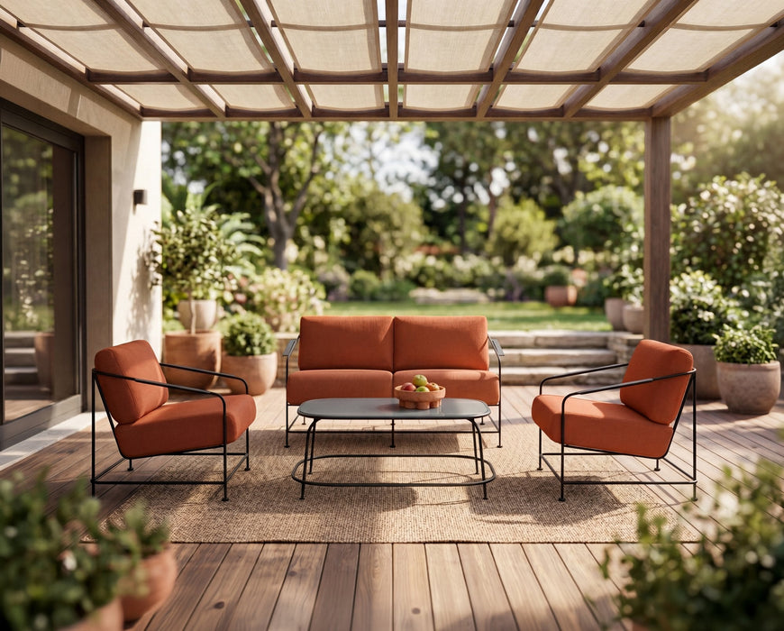 Woodard Reed 4-piece lounge set: sofa, two lounge chairs and coffee table with rust cushions on a covered patio