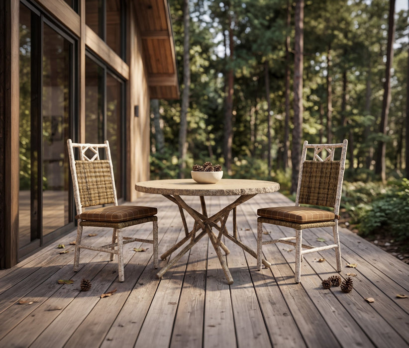 Woodard River Run 3-piece dining set: 48-inch round table and two side chairs on a wooded deck