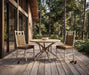 Woodard River Run 3-piece dining set: 48-inch round table and two side chairs on a wooded deck