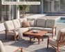 Woodard Cortland curved sectional on a poolside patio, shown in the 5-piece configuration (this set is 4 pieces)