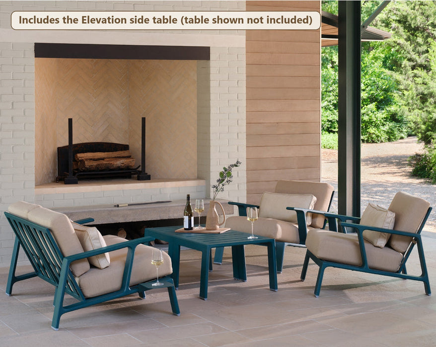 Woodard Elevation love seat and two lounge chairs by an outdoor fireplace (the set includes the Elevation side table; coffee table shown not included)